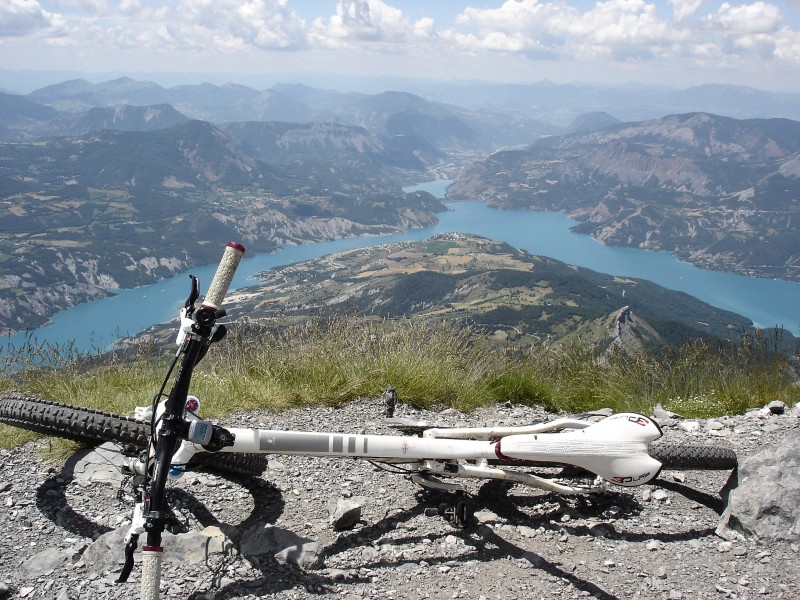 Lac de Serre-Ponçon : Le Zesty sur fond de lac de Serre-Ponçon, avec le barrage entre branche ubayenne et branche embrunaise.